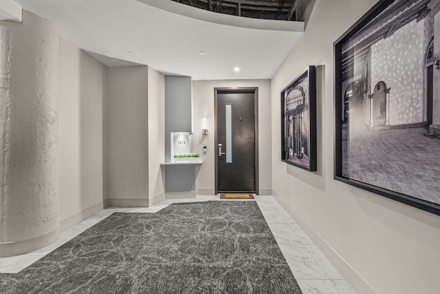 interior space featuring marble finish floor, baseboards, and elevator