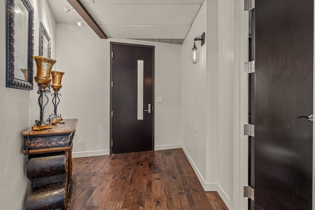 foyer with baseboards and dark wood-type flooring