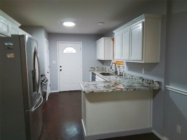 kitchen with light stone counters, stainless steel refrigerator with ice dispenser, white cabinets, a sink, and a peninsula