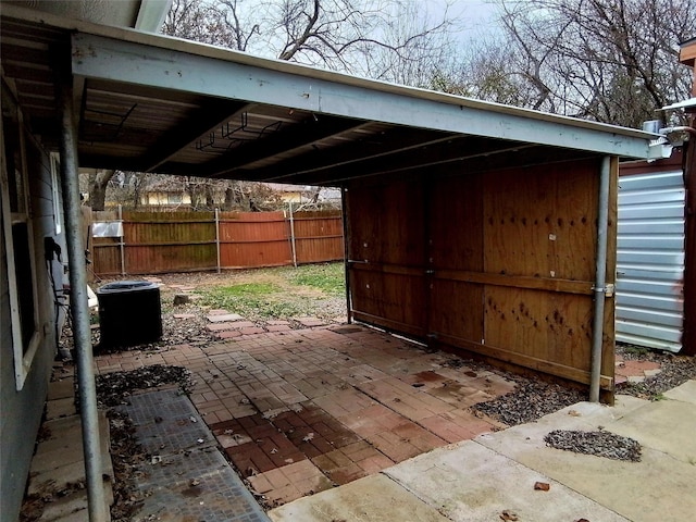 view of patio with a carport, central AC, and fence