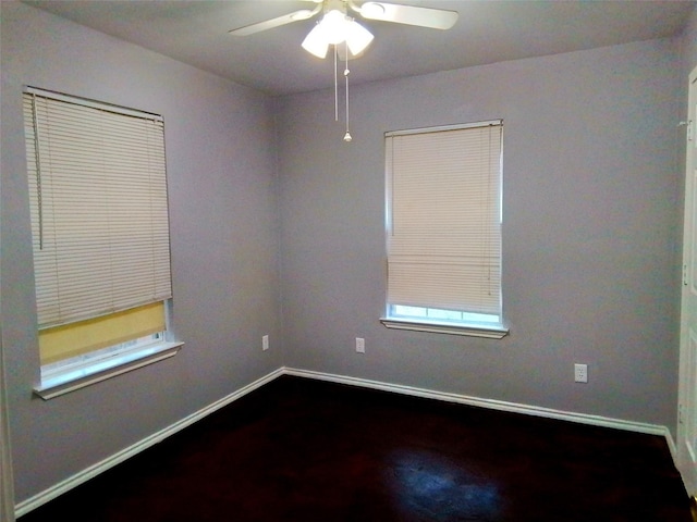 empty room with a ceiling fan, baseboards, and wood finished floors