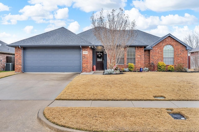 ranch-style house with a garage, cooling unit, and a front lawn