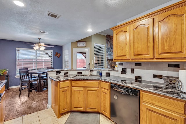 kitchen featuring dishwasher, dark stone counters, backsplash, sink, and kitchen peninsula