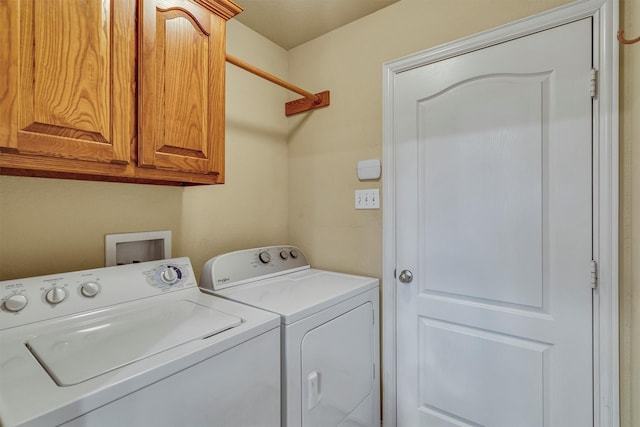 clothes washing area featuring cabinets and washing machine and clothes dryer