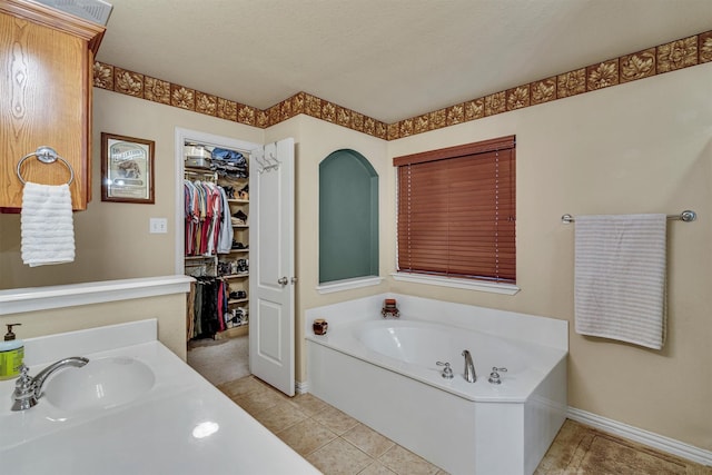 bathroom featuring sink, tile patterned flooring, a textured ceiling, and a bath