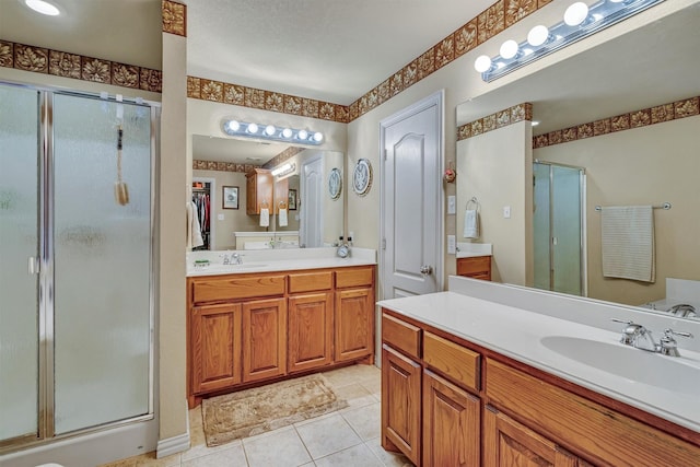 bathroom featuring tile patterned floors, a shower with door, and vanity