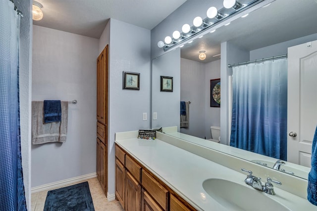 bathroom with vanity, toilet, and tile patterned floors