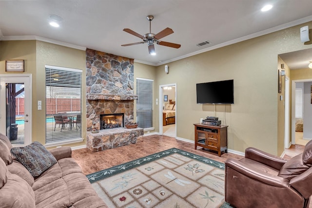 living room featuring a fireplace, ornamental molding, and light wood-type flooring