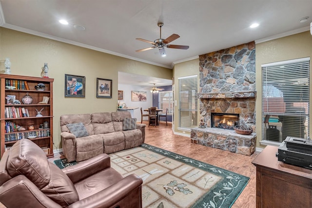 living room with a fireplace, hardwood / wood-style floors, crown molding, and ceiling fan