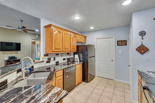 kitchen featuring sink, light tile patterned flooring, dark stone counters, ceiling fan, and black appliances