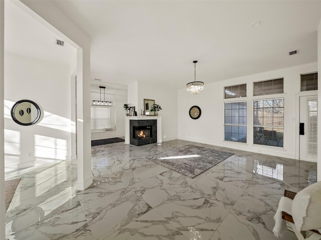 unfurnished living room featuring a fireplace and an inviting chandelier