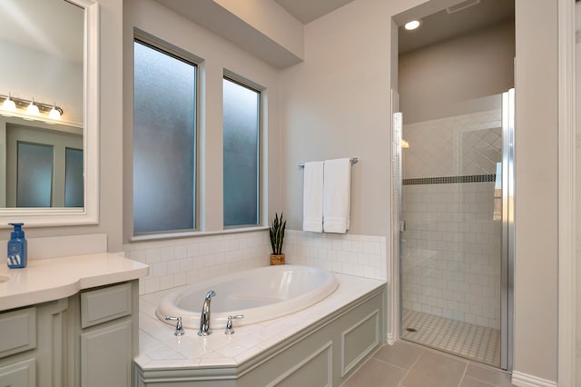 bathroom with plus walk in shower, tile patterned flooring, and vanity