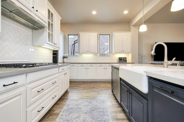 kitchen featuring white cabinetry, custom range hood, and decorative light fixtures