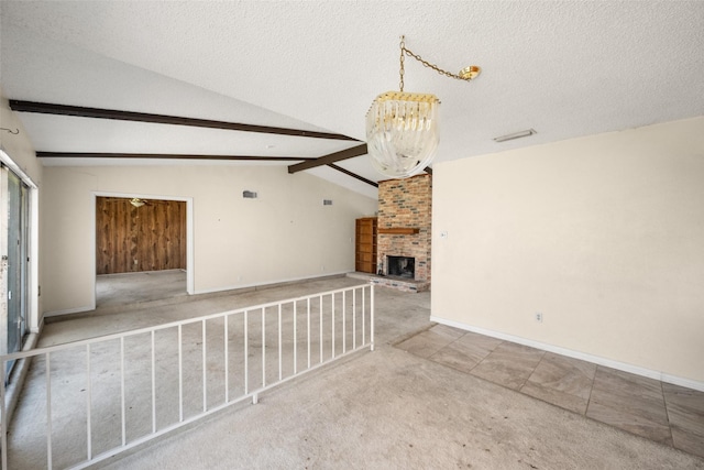 interior space with vaulted ceiling with beams, a textured ceiling, carpet floors, a fireplace, and baseboards