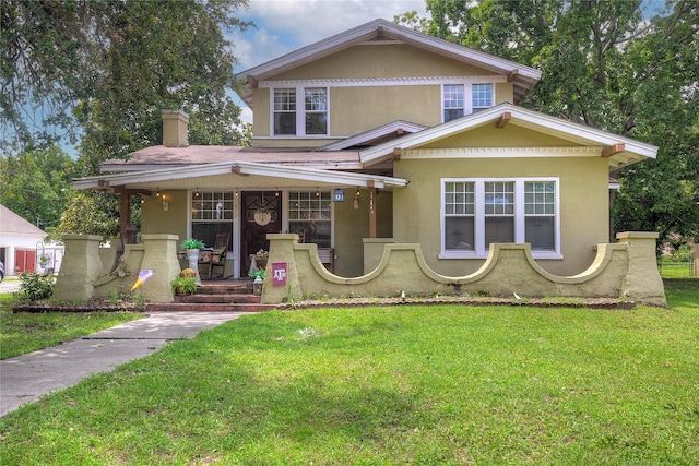 view of front of home featuring covered porch and a front lawn