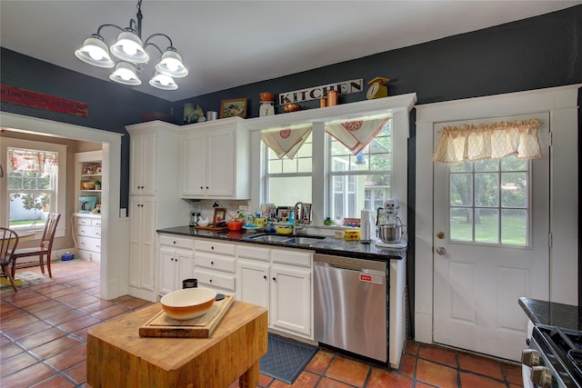 kitchen with appliances with stainless steel finishes, sink, white cabinets, and a healthy amount of sunlight