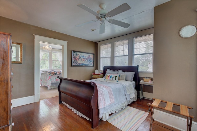 bedroom with ceiling fan with notable chandelier and wood-type flooring