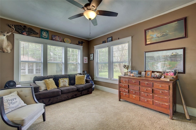 living room with ornamental molding, light colored carpet, and ceiling fan