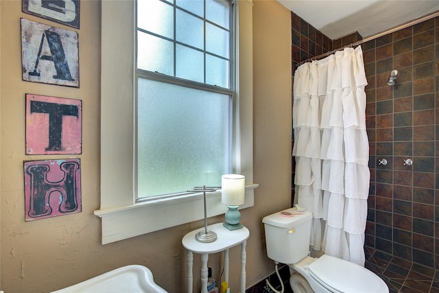 bathroom featuring a shower with shower curtain and toilet