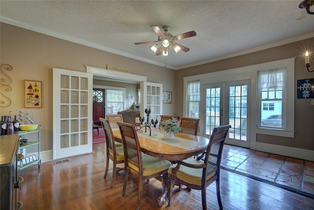 dining space featuring hardwood / wood-style floors, a textured ceiling, ceiling fan, french doors, and ornamental molding