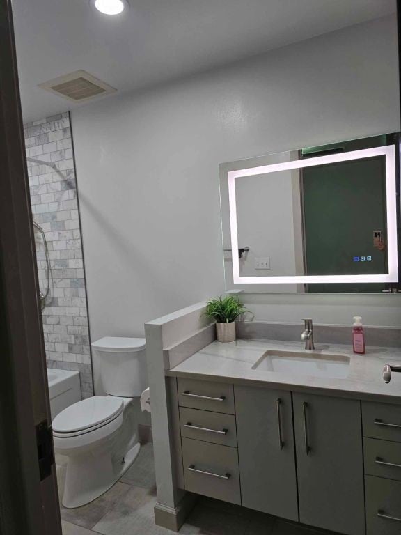 full bathroom with toilet, bathtub / shower combination, and vanity