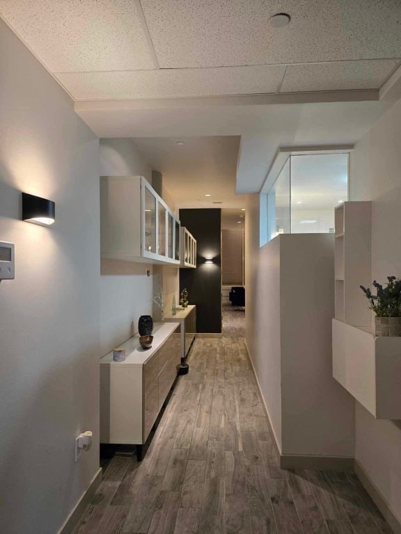 hallway featuring dark hardwood / wood-style flooring and a drop ceiling