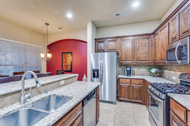 5320 Locust Dr, Mckinney, TX 75070 - kitchen with appliances with stainless steel finishes, a sink, a chandelier, decorative backsplash, and light stone countertops