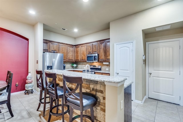 5320 Locust Dr, Mckinney, TX 75070 - kitchen featuring stainless steel appliances, light tile patterned floors, a center island with sink, backsplash, and recessed lighting