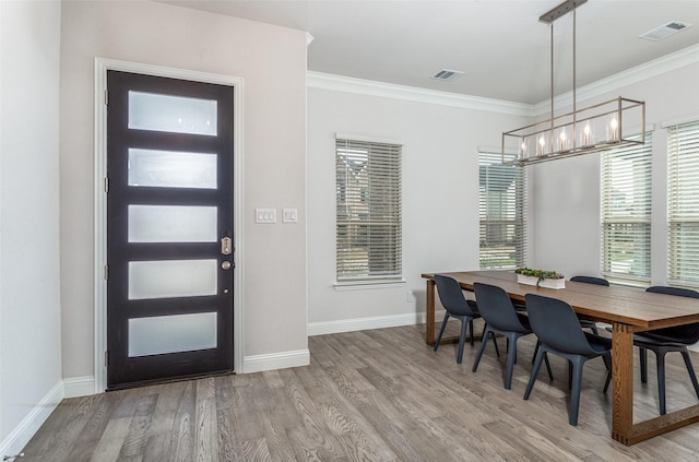 dining area featuring a notable chandelier, hardwood / wood-style flooring, and ornamental molding