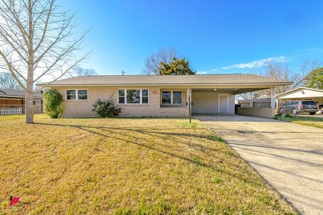 ranch-style house featuring a carport, concrete driveway, and a front lawn