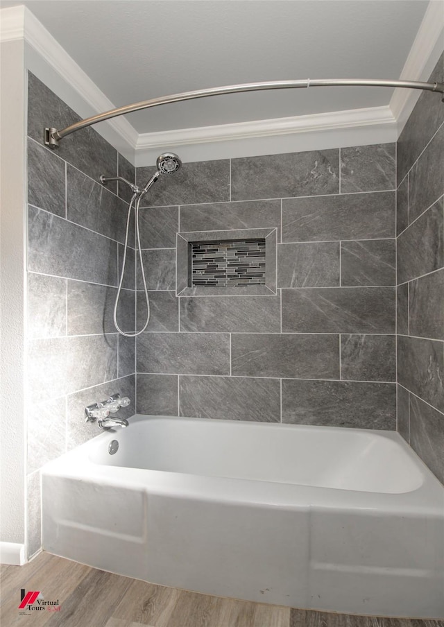 bathroom with hardwood / wood-style flooring, crown molding, and tiled shower / bath