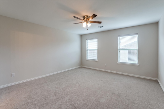 empty room featuring ceiling fan and light carpet