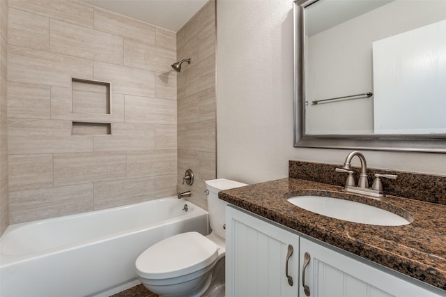 full bathroom with toilet, vanity, and tiled shower / bath