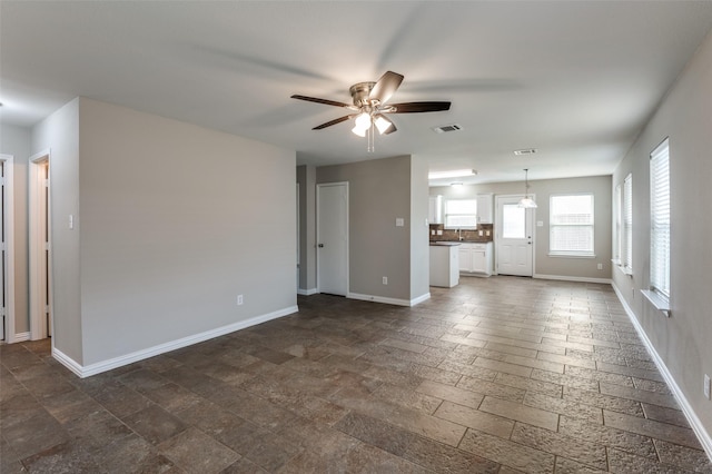 unfurnished living room with ceiling fan and sink