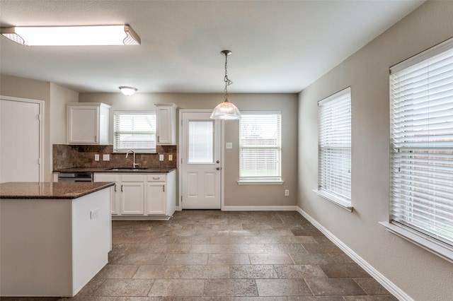 kitchen with dishwashing machine, white cabinets, decorative backsplash, pendant lighting, and sink