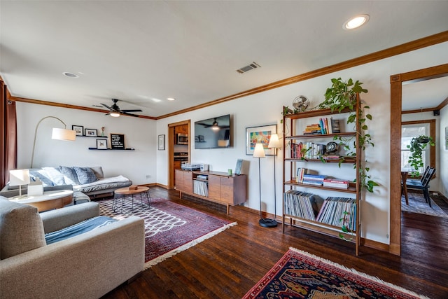 living room with ceiling fan, dark hardwood / wood-style flooring, and ornamental molding