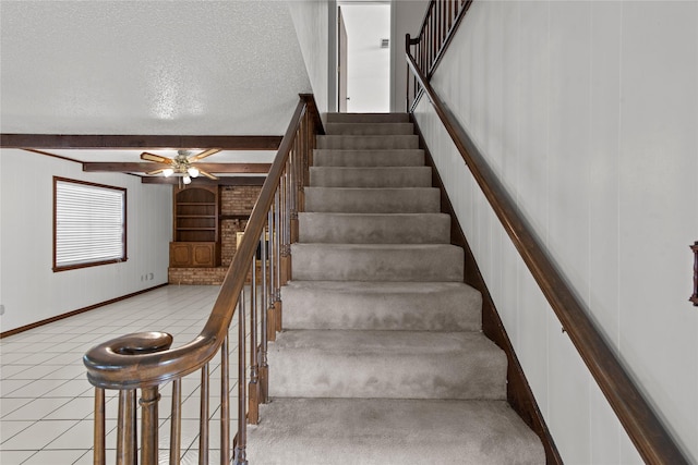 5570 Bretwood Dr, Keithville, LA 71047 - stairway featuring built in shelves, beam ceiling, tile patterned floors, ceiling fan, and a textured ceiling