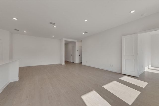 unfurnished room with visible vents, baseboards, recessed lighting, and light wood-style floors
