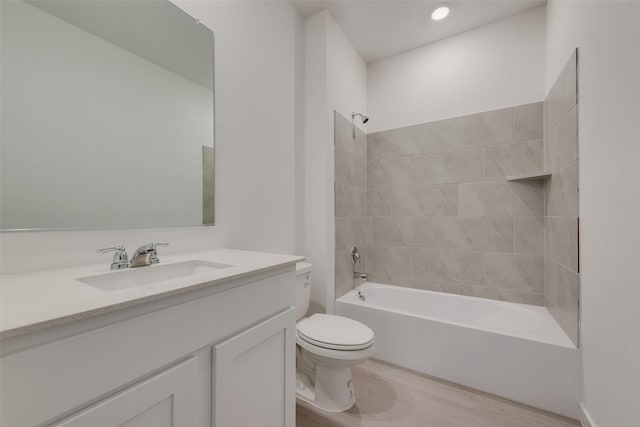full bathroom featuring toilet, wood finished floors, vanity, and tub / shower combination