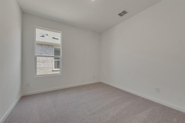 spare room featuring visible vents, baseboards, and carpet floors