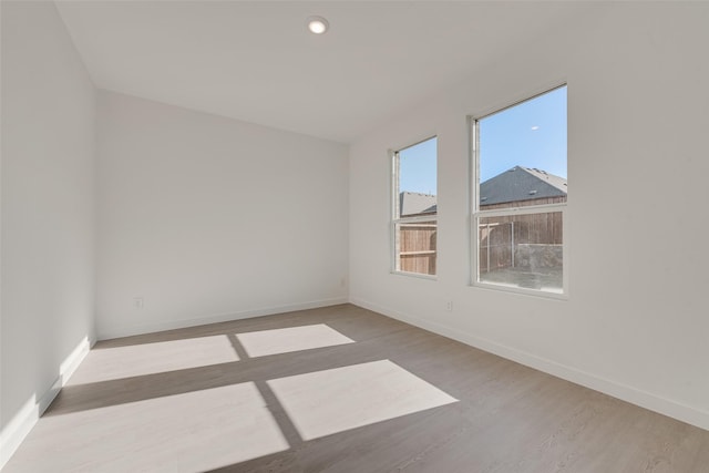 spare room featuring wood finished floors and baseboards