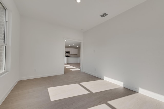 spare room featuring recessed lighting, visible vents, baseboards, and wood finished floors