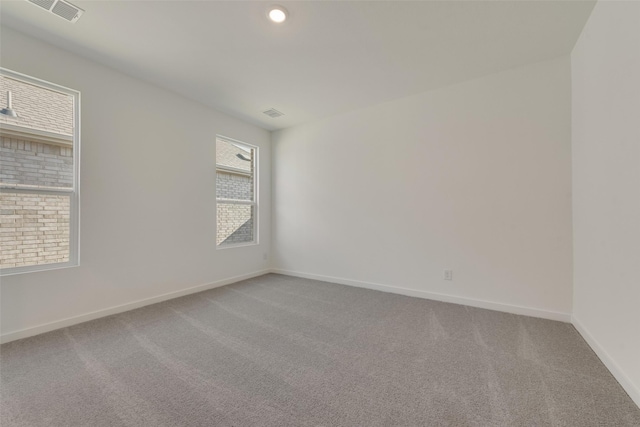 empty room with visible vents, baseboards, and carpet floors