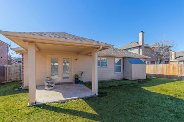 back of property with a yard, a patio area, and fence