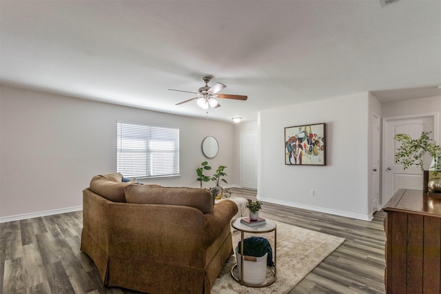 living room featuring dark wood-style floors, baseboards, and a ceiling fan