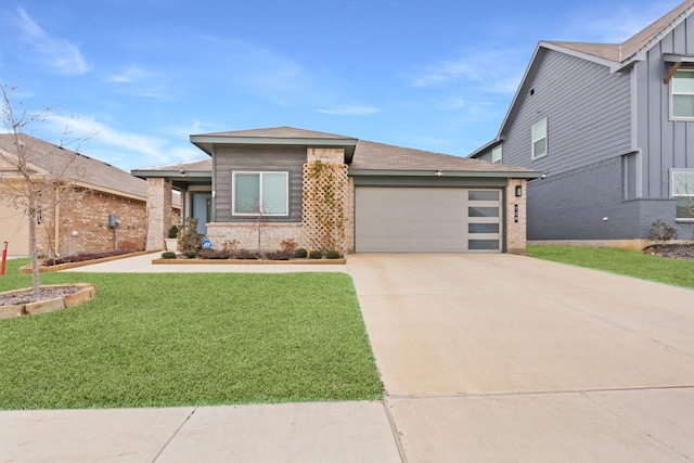 view of front of house with driveway, a front lawn, an attached garage, and brick siding