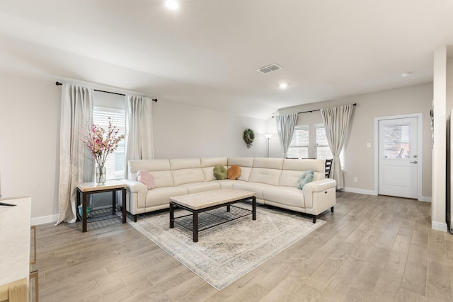 living room featuring light wood-type flooring, visible vents, baseboards, and recessed lighting