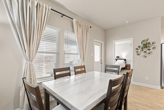 dining room with light wood finished floors and baseboards