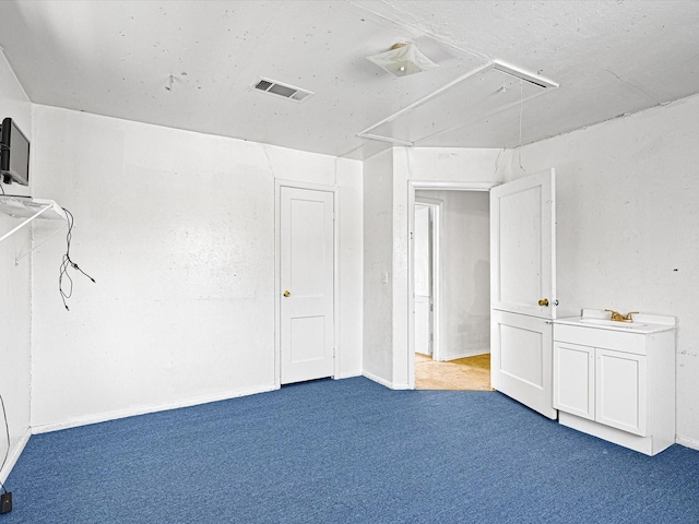 unfurnished bedroom featuring dark carpet and sink