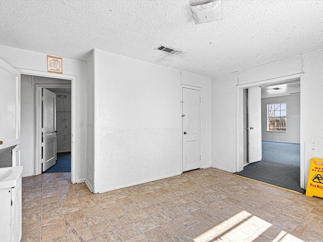 unfurnished room with a textured ceiling